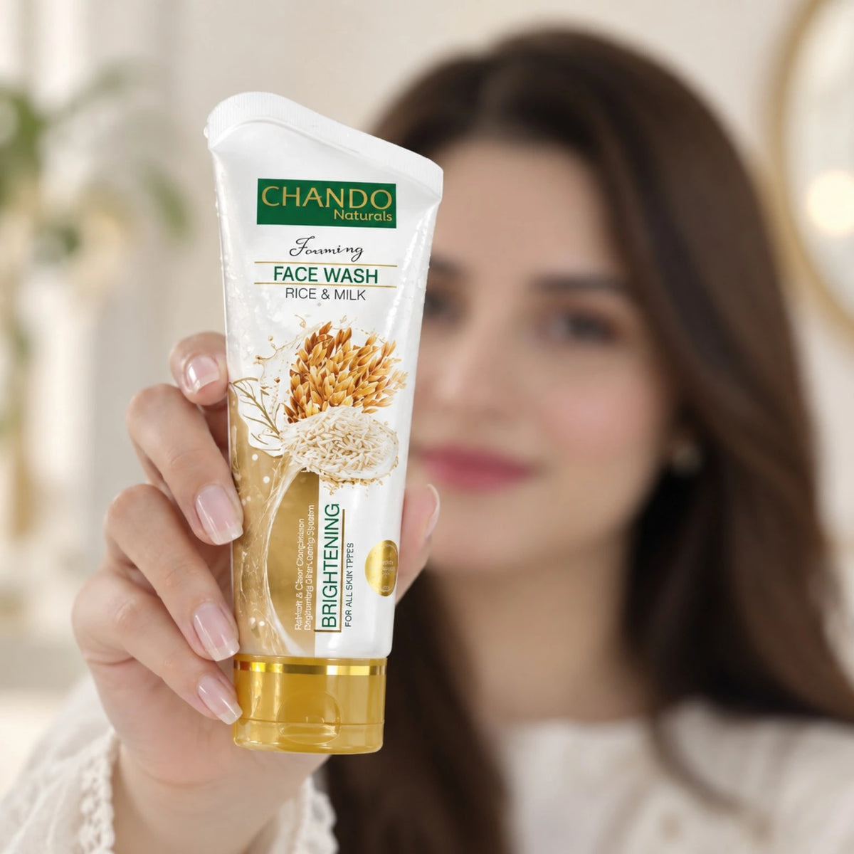 Chando Rice & Milk Brightening Face Wash held by a model for gentle facial cleansing