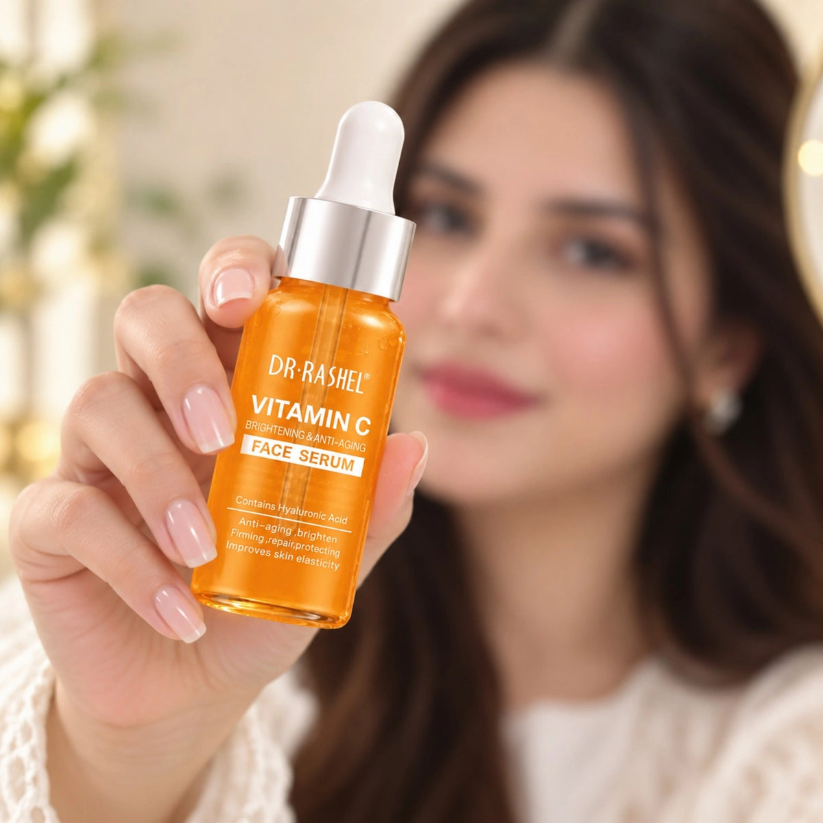 Dr Rashel Vitamin C brightening anti-aging face serum held by a woman