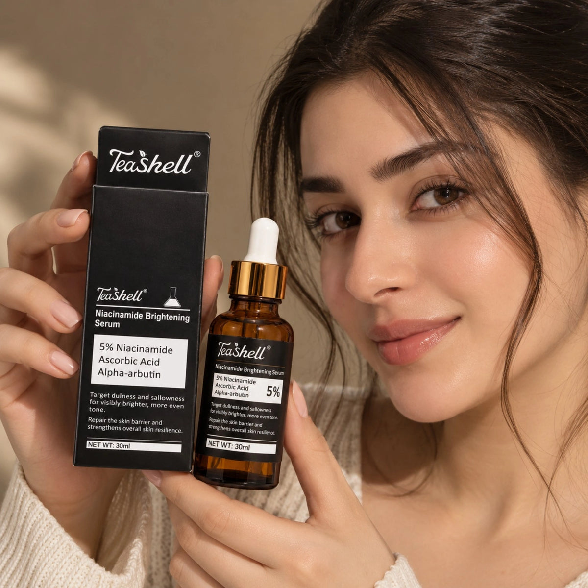 Teashell 5% niacinamide brightening serum with alpha arbutin and vitamin C held by a model